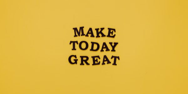Simple and motivational quote 'Make Today Great' on a minimalist yellow background for inspiration.
